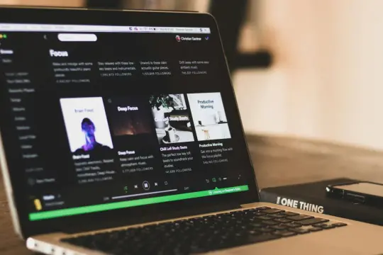 Laptop z otwartym Spotify, na ekranie playlisty do skupienia. Szukasz informacji, jak wyłączyć Spotify Premium?